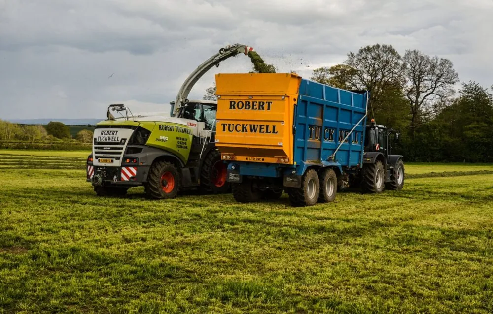 Forage harvester loading a Robert Tuckwell trailer in a grass field