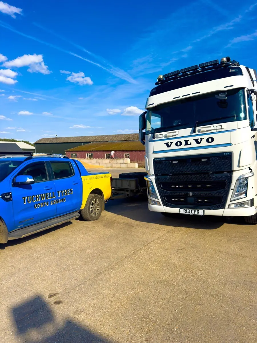 Tuckwell Tyres blue and yellow service pickup beside a Volvo lorry